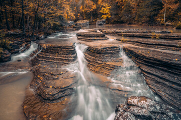 Six finger falls cascading water flows over layered rocks at Richland Creek, a national forest camping area deep in the Ozark Mountains of Arkansas. 