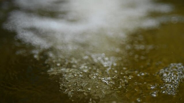 Bubbles on water in a pool  of a mountain river (slow motion, bokeh)