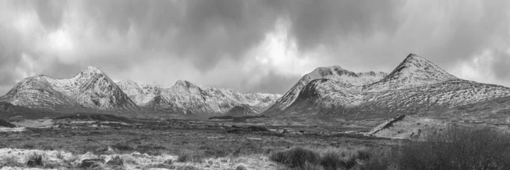 Poster Zwart-wit majestueuze winterpanorama landschapsbeeld van bergketen en toppen gezien vanaf Loch Ba in de Schotse Hooglanden met dramatische wolken boven © veneratio