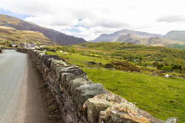 Rural Welsh Scene. Stone wall by road overlooking valley, wide angle.
