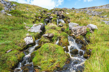 Pennine Way is a National Trail in England, with a small section in Scotland. Walk towards High Cup Nick, Cumbria. Water running down the hill