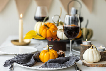 Idea for a beautiful autumn setting for thanksgiving family dinner or wedding. Orange pumpkin as decor. Cozy fall home atmosphere.