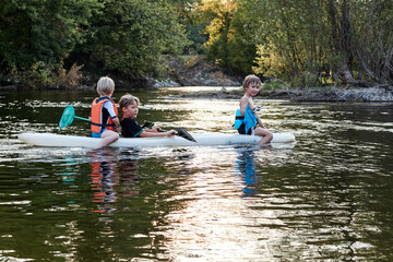 trois enfants jouent sur un kayak en dordogne - obrazy, fototapety, plakaty
