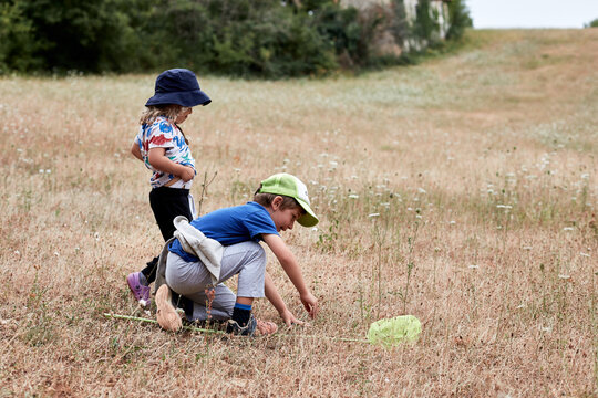 Joyeux &eacute;t&eacute;, deux enfants en plein jeu dans une prairie chasse les insectes