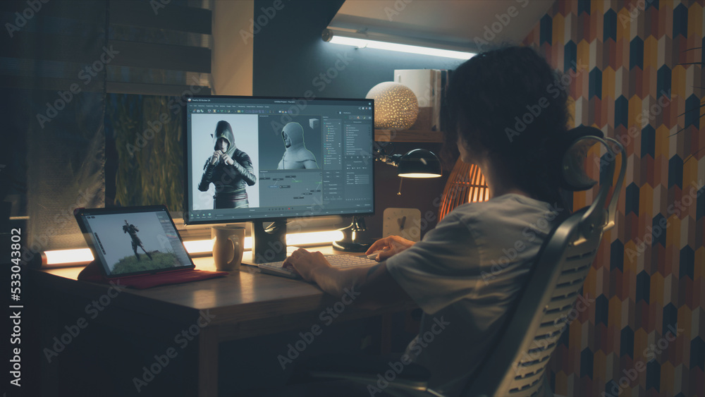 Poster male 3d designer sitting at the table at home and making animation for video game character, using m