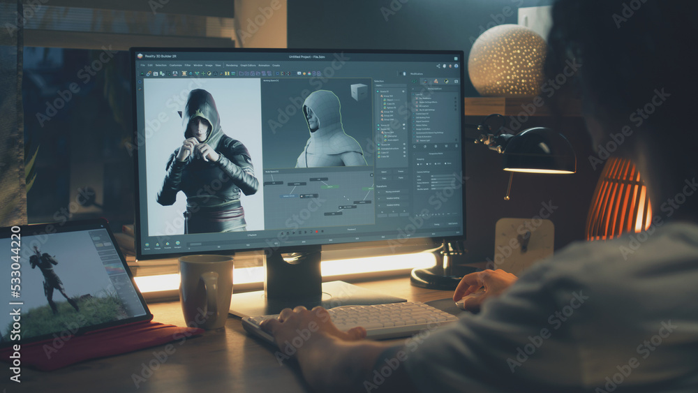 Fototapete male 3d designer sitting at the table at home and making animation for video game character, using m