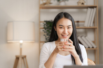 Confident smiling asian woman in creative home office looking at camera.