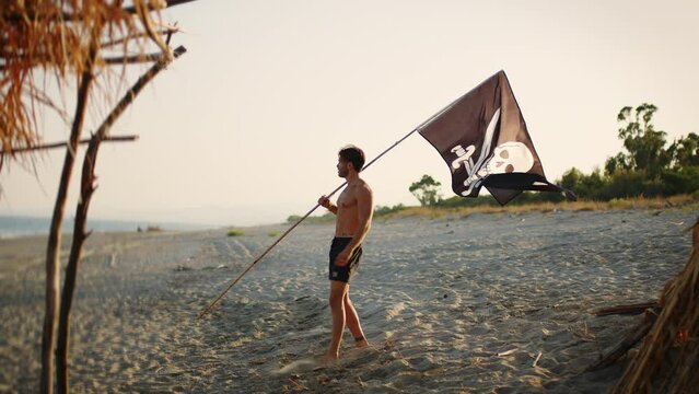 Pirate plants black flag with skull on desert island