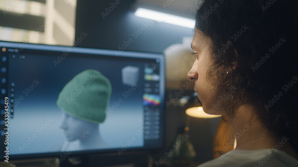 Poster Guy sitting at the table and designing clothes in 3D modeling professional program on personal computer while working remotely from home