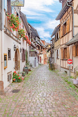 scenic small road with half timbered houses in the historic village of Eguisheim in the Alsace region