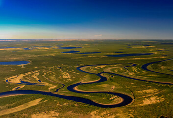 Flat northern tundra from a helicopter at the beginning of the Arctic summer.