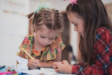 Creative kids sitting in a preschool institution, draw and have fun while they get an education