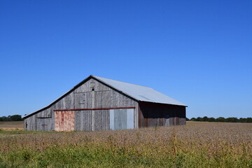 Fototapeta na wymiar Wooden Barn in a Farm Field
