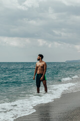 a photo of a man posing on the beach 