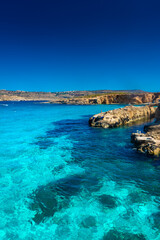 Comino, Malta, 22 May 2022:  Tourists swimming in the crystal clear water of the Blue Lagoon