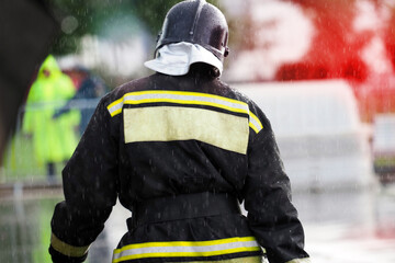 Firefighter with protective uniform in a hurry to extinguish the fire, rear view