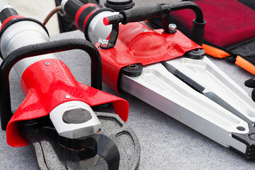 Hydraulic rescue tools, hydraulic shears and spreader for saving people from damaged cars in road accidents. Rescue service equipment with hydraulic booster. Emergency situations tech