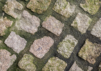 Stone pavement texture. Granite cobbled pavement background. Traditional rustic pavers....