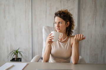 One young woman during the break drinking coffee in the office