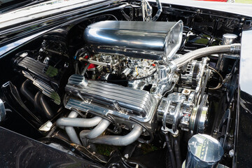 Fototapeta na wymiar Muscle Car Engine with dual carburetors, headers and lots of shiny chrome.