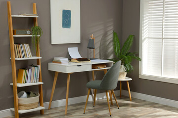 Fototapeta premium Comfortable writer's workplace interior with typewriter on desk near grey wall