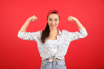 Strong woman as symbol of girl power on red background. 8 March concept