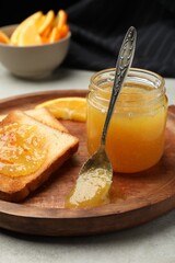 Delicious toasts with orange marmalade on table, closeup
