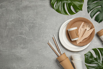 Fototapeta Flat lay composition with disposable tableware and monstera leaves on light grey background, space for text obraz