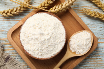 Fototapeta na wymiar Organic wheat flour on light wooden table, flat lay