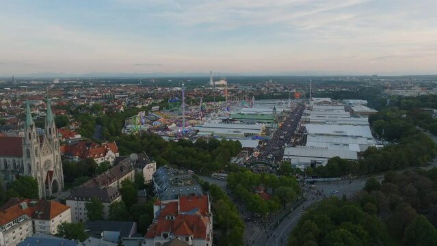Aerial panoramic view of crowded Oktoberfest grounds at dusk. Largest folk festival in world with high capacity beer tents and great amusement park. Munich, Germany