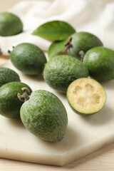 Fresh green feijoa fruits on white cutting board, closeup