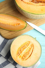 Tasty fresh melons on light blue wooden table, flat lay
