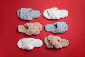 Fototapeta na wymiar Different soft fluffy slippers on red background, flat lay