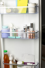 Fototapeta na wymiar Different cosmetic products on shelves in refrigerator