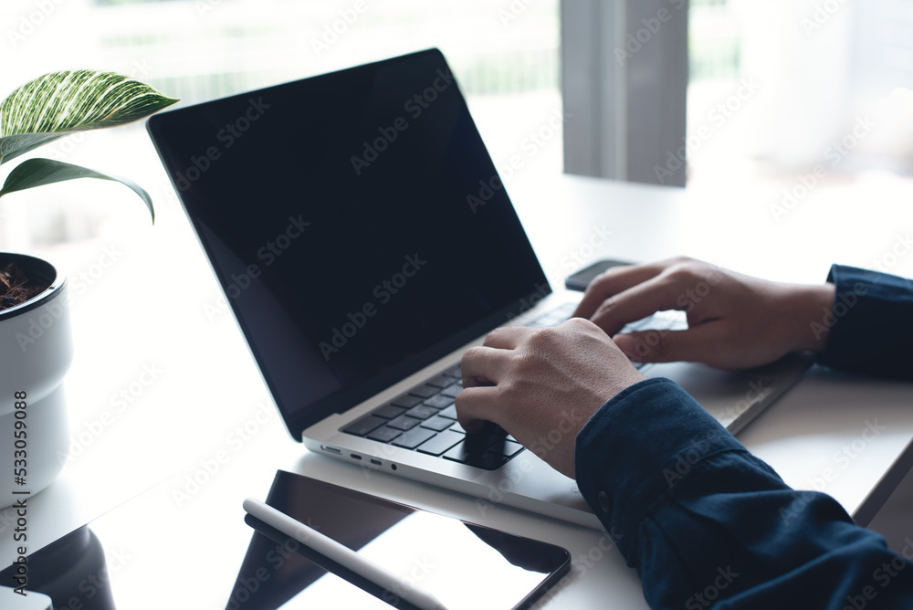 Poster businessman working on laptop computer at home office. casual business man, freelancer using portabl