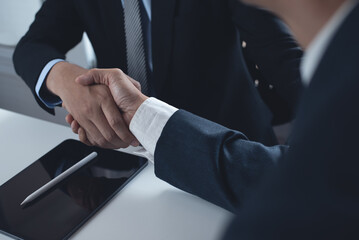 Business handshake. Two businessmen shaking hand after signing business contract at office,...