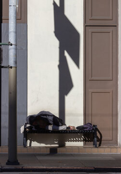 Homeless person sleeping on a public bench in San Francisco during the COVID-19 pandemic
