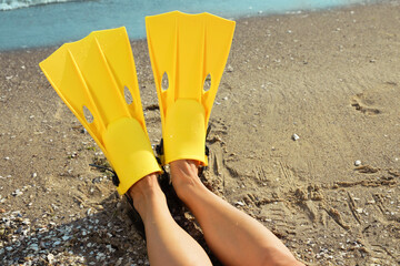 Woman in yellow flippers on beach, closeup © New Africa