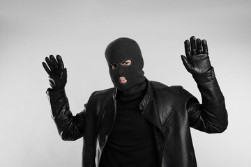 Man wearing knitted balaclava on light grey background