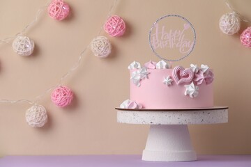 Beautifully decorated birthday cake on violet table