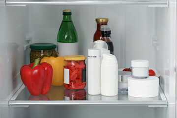 Different cosmetic products on shelf in refrigerator