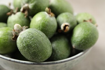 Fresh green feijoa fruits in bowl, closeup. Space for text