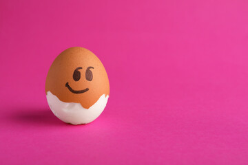 Egg with drawn face on pink background, space for text. Exhibitionist concept