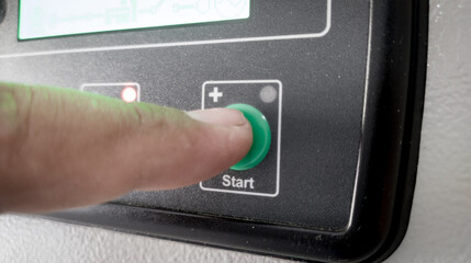 the man finger press the button control on modul operating machine to start machine.