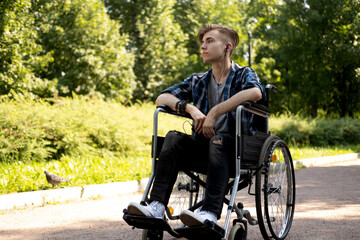young disabled man in wheelchair walking park