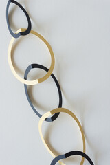 folded black and yellow paper rings arranged in the form of a chain on blank paper