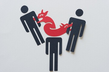 three stylized figures (stick figure dingbats) with doubled headed paper dragon  