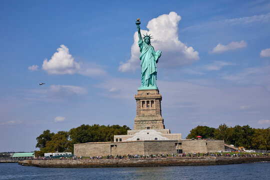 Statue of Liberty in New York City harbor welcoming visitors on a sunny summer day
