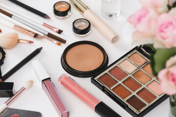 make-up tools and cosmetics on white table. Decorative cosmetics, brushes, eyes shadow, pencils with foundation on dressing table or beauty salon