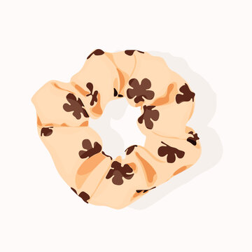 A cream scrunchie that is in the shape of a circle, as well as a scrunchie. 